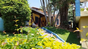 A courtyard with a hammock, a water tank, and a pathway. - Chácara Sorriso 1 (Atibaia)