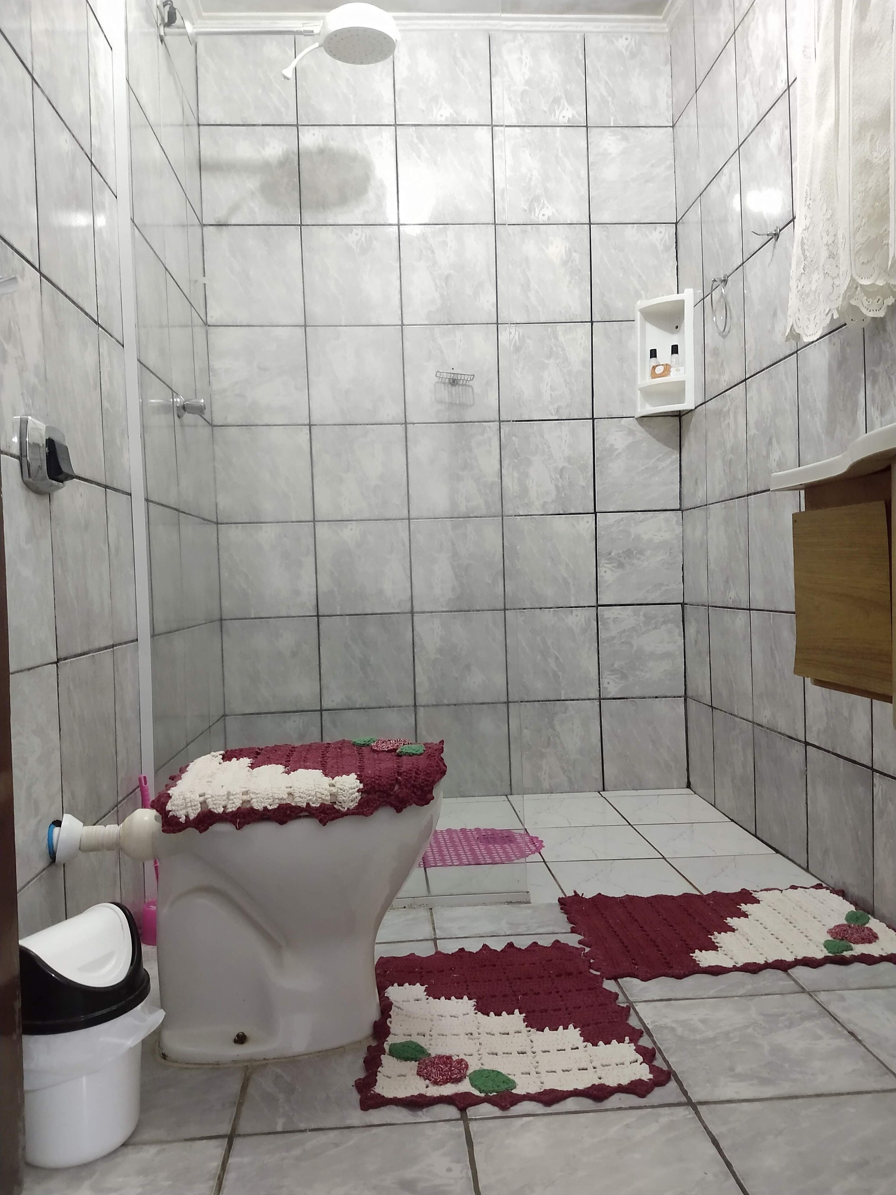A bathroom with a toilet, a shower, and a sink.
