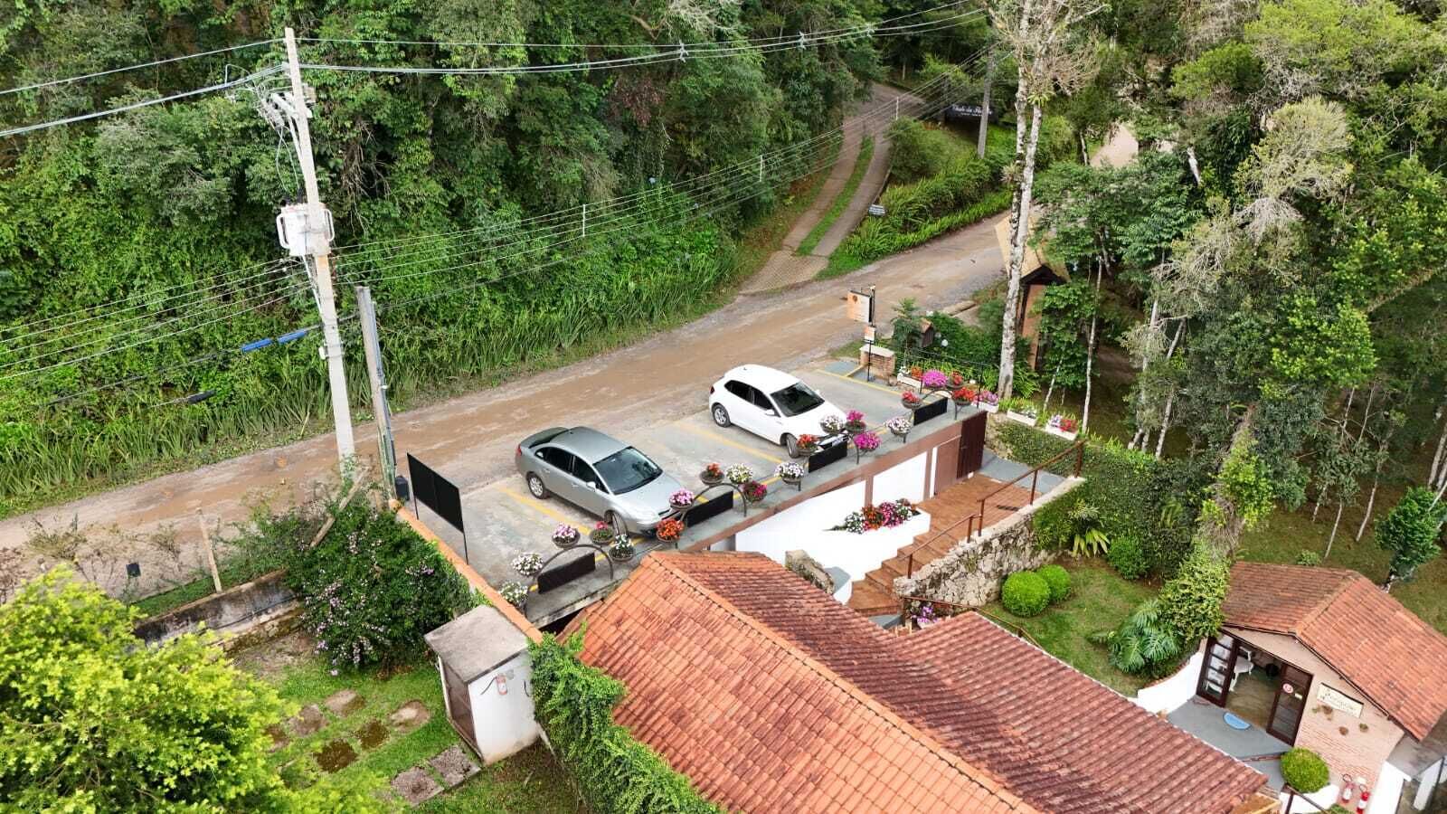A residential area with a house featuring a red-tiled roof, a driveway, and a parked car.