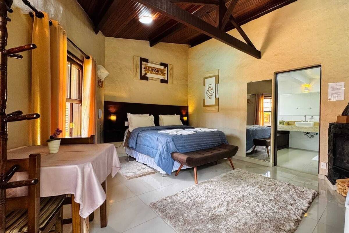 Un dormitorio con cama, mesita de noche y chimenea.