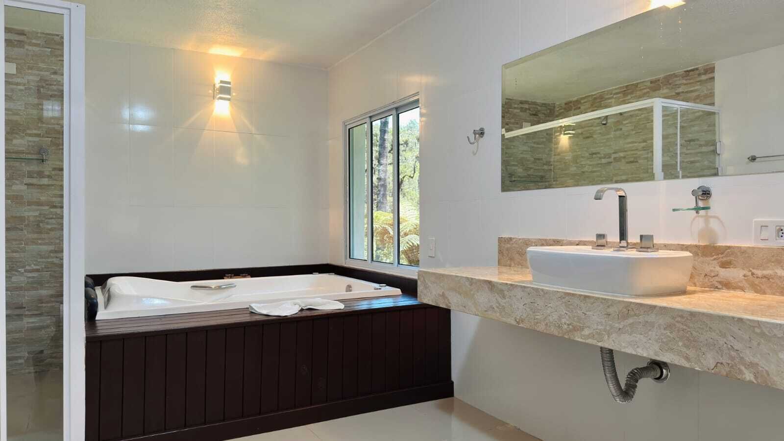 A modern bathroom with a bathtub, a sink, and a large mirror.
