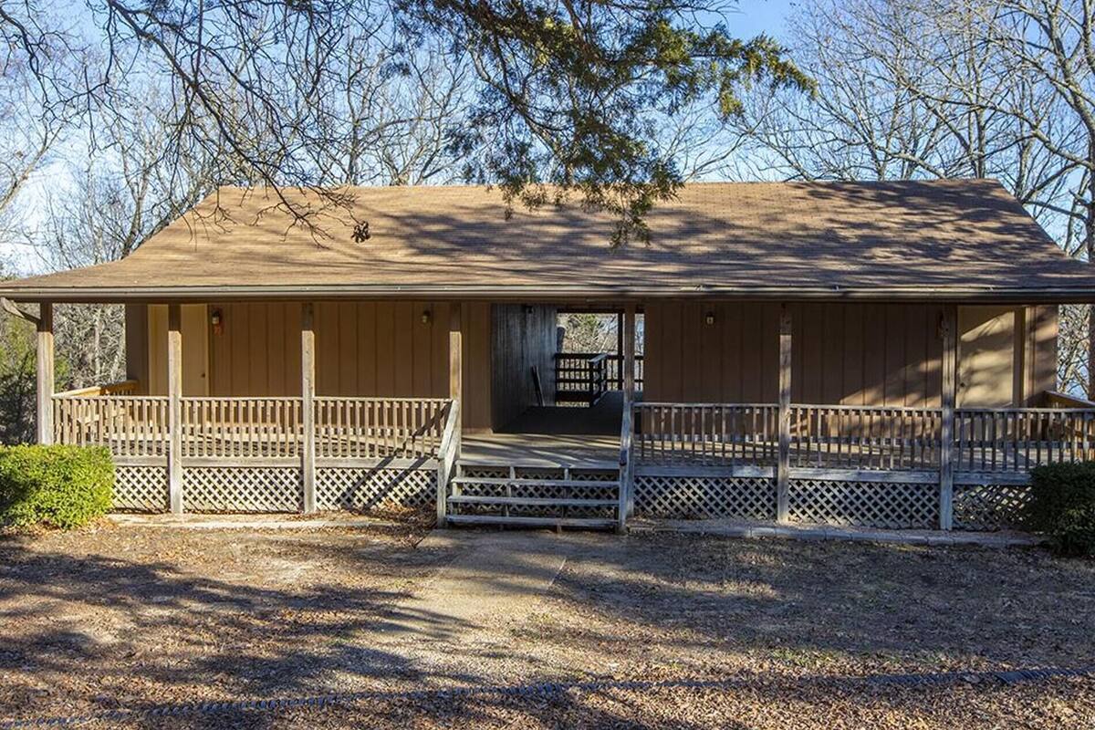 A wooden cabin with a covered porch and a small front entrance.