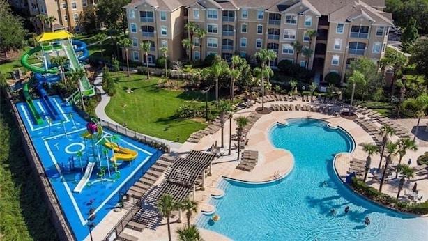 A hotel with a swimming pool, a water park, and a landscaped area with palm trees. - Three BR * 2 Miles to Disney, pool, free WiFi and more (Kissimmee)
