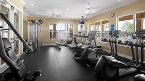 A gym with cardio equipment, weight machines, and a mirrored wall. - Three BR * 2 Miles to Disney, pool, free WiFi and more (Kissimmee)