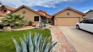 A residential house with a garage, a driveway, and a well-maintained lawn with agave plants. - Waterfront, LuxuryVilla with Private Pool- (Chandler)