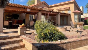 A house with a patio area, outdoor seating, and a garden. - Waterfront, LuxuryVilla with Private Pool- (Chandler)