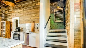A rustic kitchen with wooden walls, a marble countertop, and a staircase with a green wall. - Downtown+FREE Parking+Walk Everywhere+Forsyth Park (Savannah)