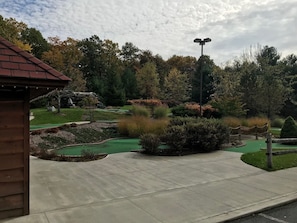 Ein Golfplatz mit einem Betonweg, einem Holzgebäude und einer solarbetriebenen Straßenlaterne.