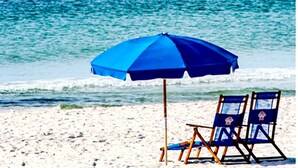 Une scène de plage avec un parasol bleu et deux chaises de plage.
