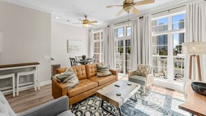 A spacious living room with a leather sofa, a coffee table, and a dining area with a table and chairs.