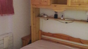 A single bed with a wooden headboard and a wooden cabinet above it. - Apartment La Tania Courchevel 4 to 6 people<br> at the foot of the slopes,  (La Tania, Courchevel)