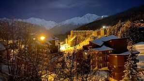 A snow-covered mountain town at night with illuminated buildings and a view of snow-capped peaks in the background. - Apartment La Tania Courchevel 4 to 6 people<br> at the foot of the slopes,  (La Tania, Courchevel)