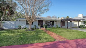 A single-story house with a front porch, a covered patio, and a well-maintained lawn. - St Armand's Home with pool (Sarasota)
