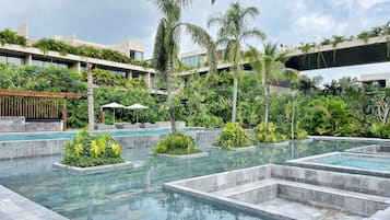 Alberca al aire libre, sombrillas en la alberca y camastros