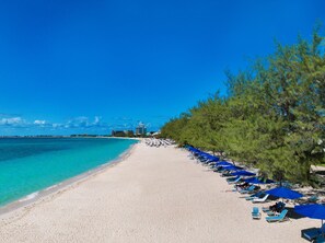 Plage, sable blanc, chaises longues, parasols
