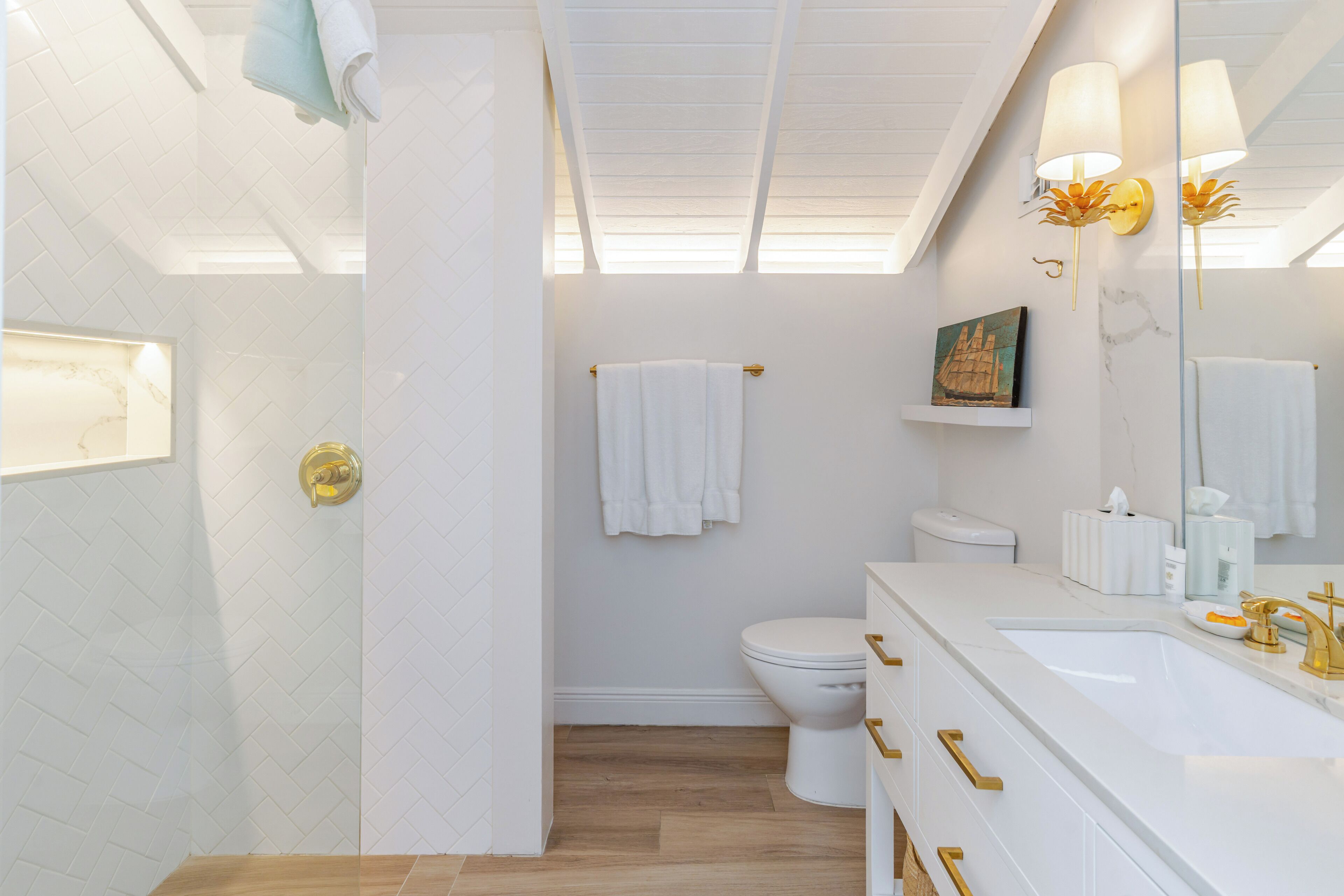 A modern bathroom with a shower, toilet, and vanity.