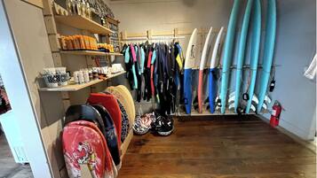 Een surfwinkel met surfplanken, wetsuits en ander surfgerief.