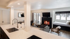 A modern kitchen with a large island, a fireplace, and a cozy seating area with a sofa and chairs. - Outpost: Cedars 1413 - Aspens Location! (Wilson)
