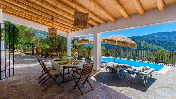 A covered outdoor dining area with a pool and mountain view. - Casa Rural Monte Dios Jubrique by Ruralidays (Málaga)