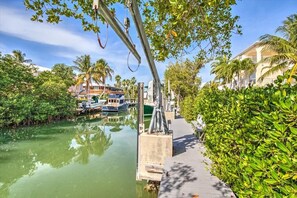 Stroll along the tranquil waterfront path, surrounded by lush greenery and residential buildings.