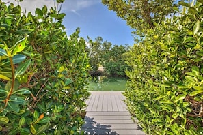 A wooden pathway leading to a body of water, surrounded by dense green foliage. - Paradise Getaway Flamingo Island, Marathon (Marathon)