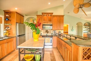 Enjoy cooking in this well-equipped kitchen with a central island, stainless steel appliances, and a sink.