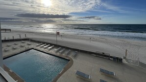 A beach view with a pool, sun, and cloudy sky. - ☀️Edgewater West 34. stocked poolside storage room.  New paint and floors!!⛱️ (Gulf Shores)