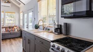 A modern kitchen with a gas stove, a coffee maker, and a sink. - Zion-Day-Trip Ready • Tiny Home + Mountain Views (Apple Valley)
