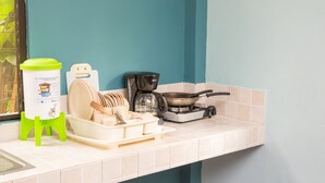 Une cuisine équipée d’un égouttoir, d’une machine à café et d’une cuisinière à gaz.