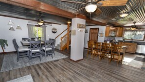 A spacious kitchen with wooden cabinets, a central island, and a dining area with a high table and chairs. - Casselman Cabin Retreat (Confluence)