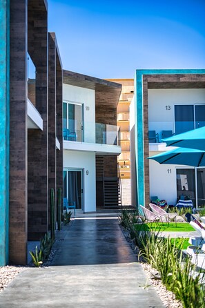 A modern building with a central courtyard, numbered rooms, and outdoor seating areas. - The Cove Boutique Hotel Adults Only (Puerto Peñasco)