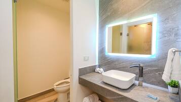 Un bagno moderno con lavabo integrato, uno specchio e zona doccia.