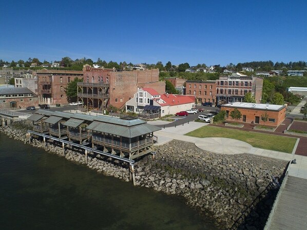 A waterfront property with a dock, buildings, and a clear sky. - Prime waterfront Suite with view (Port Townsend)