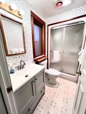 A bathroom with a sink, mirror, toilet, and shower. - Prime waterfront Suite with view (Port Townsend)