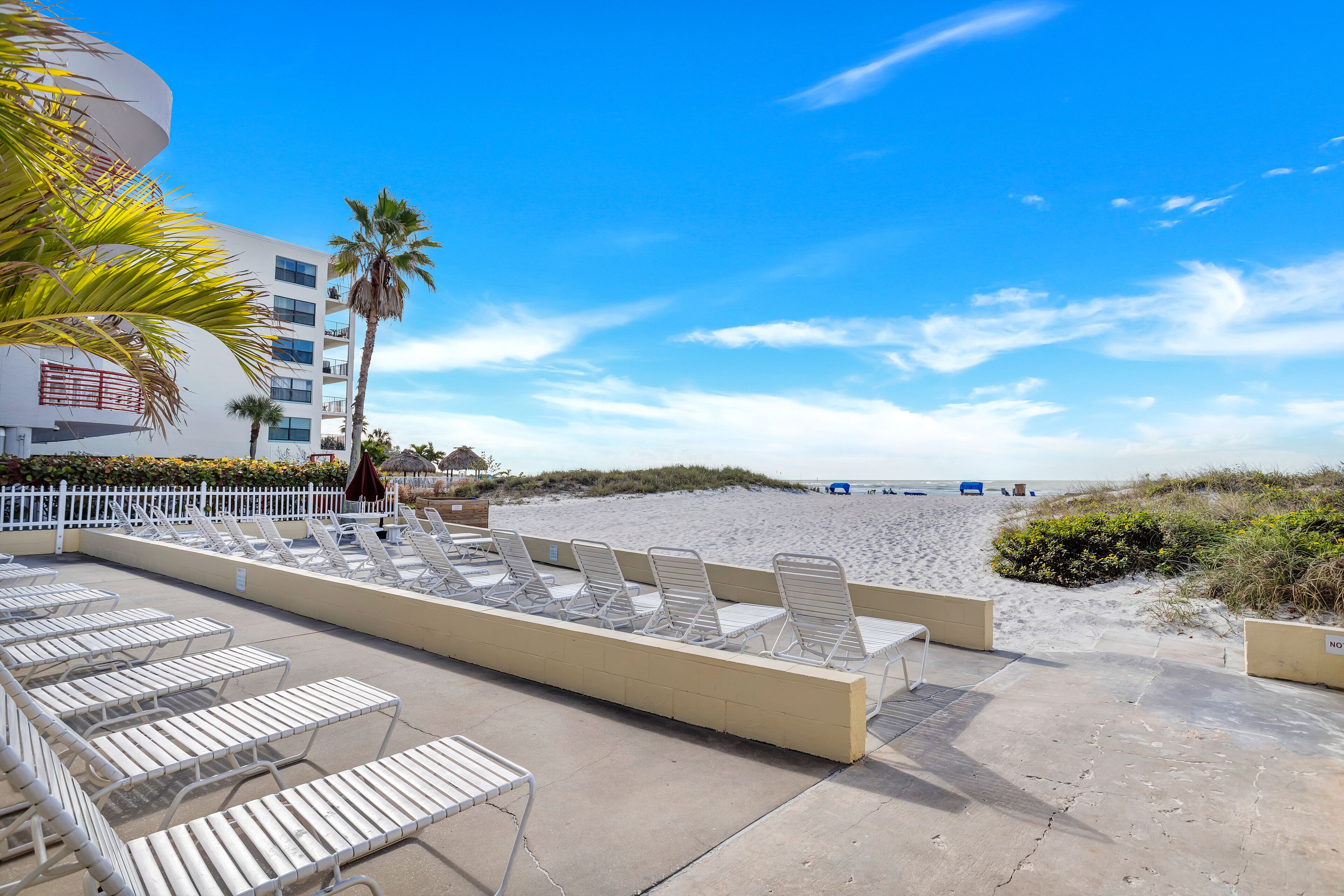 Ein Strandhotel mit Liegestühlen und einem Poolbereich.