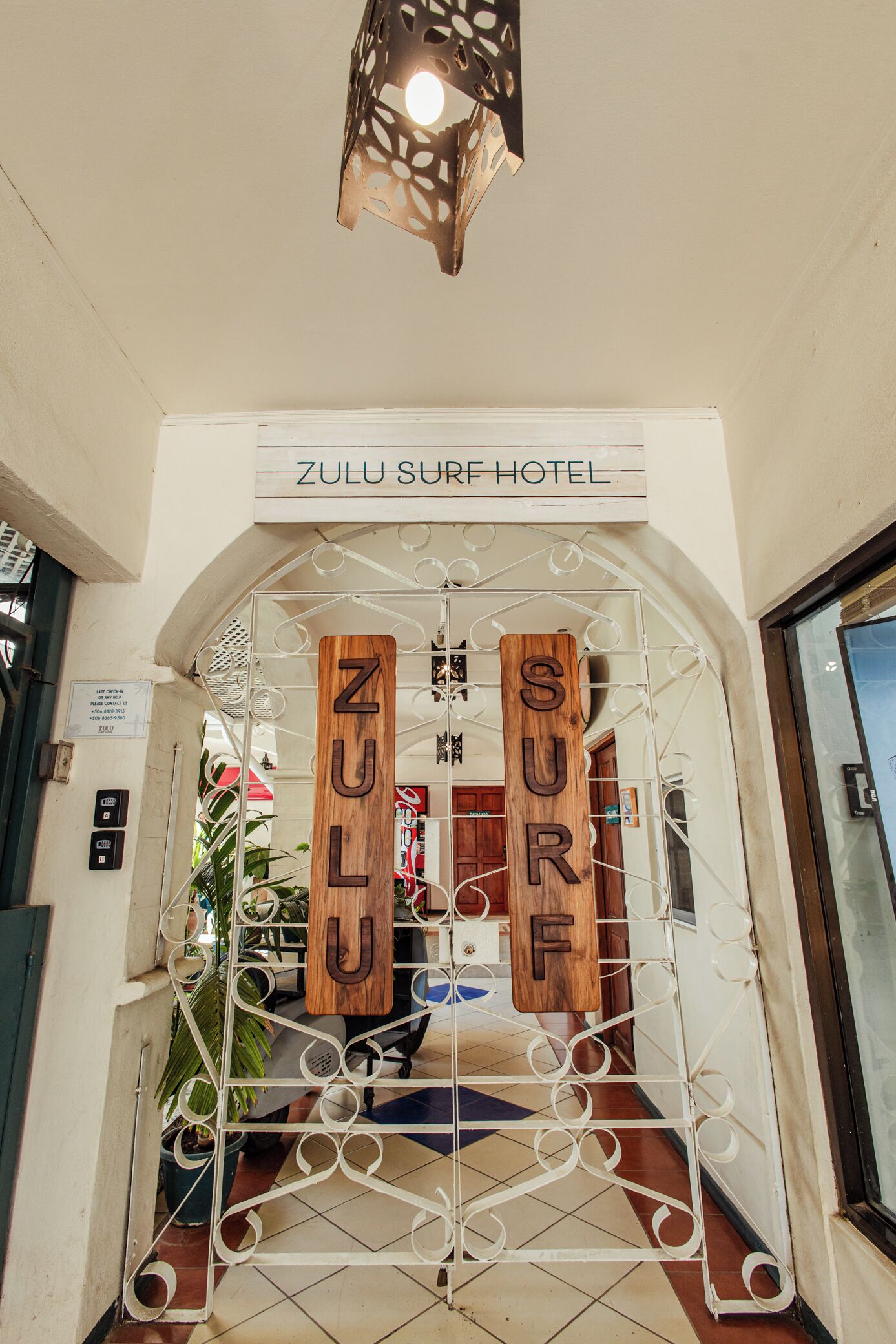 The entrance to Zulu Surf Hotel with a metal gate and wooden letters spelling "ZULU SURF HOTEL".