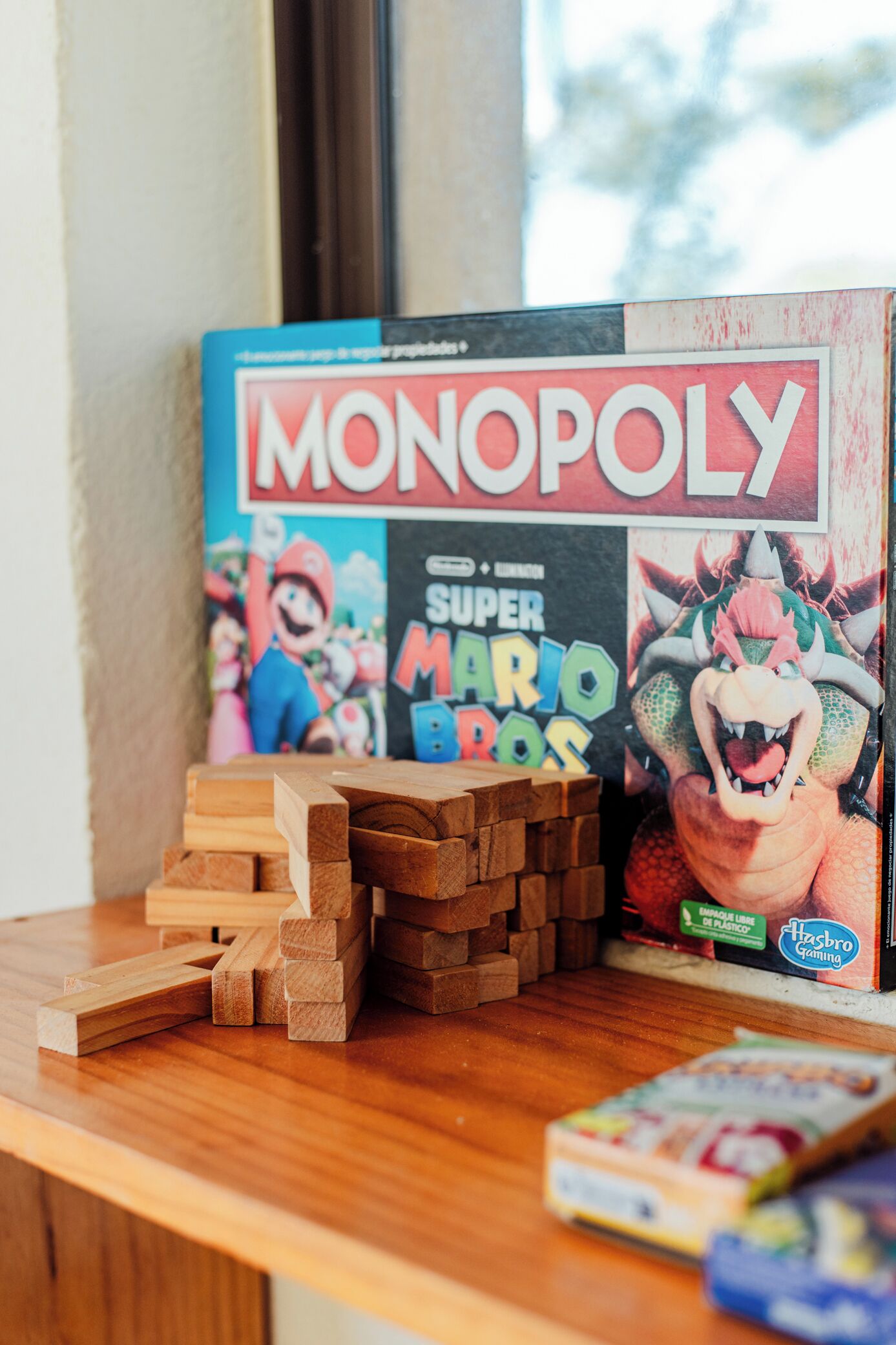 A Monopoly board game with wooden blocks stacked beside it.