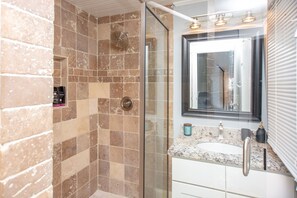 Een bad/douchecombinatie, handdoeken, toiletpapier