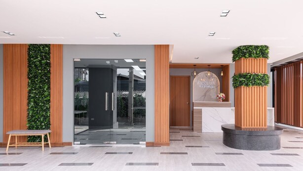 A modern reception area with a glass door, wooden paneling, and a reception desk with a logo. - Aqua Residences (Bangkok)
