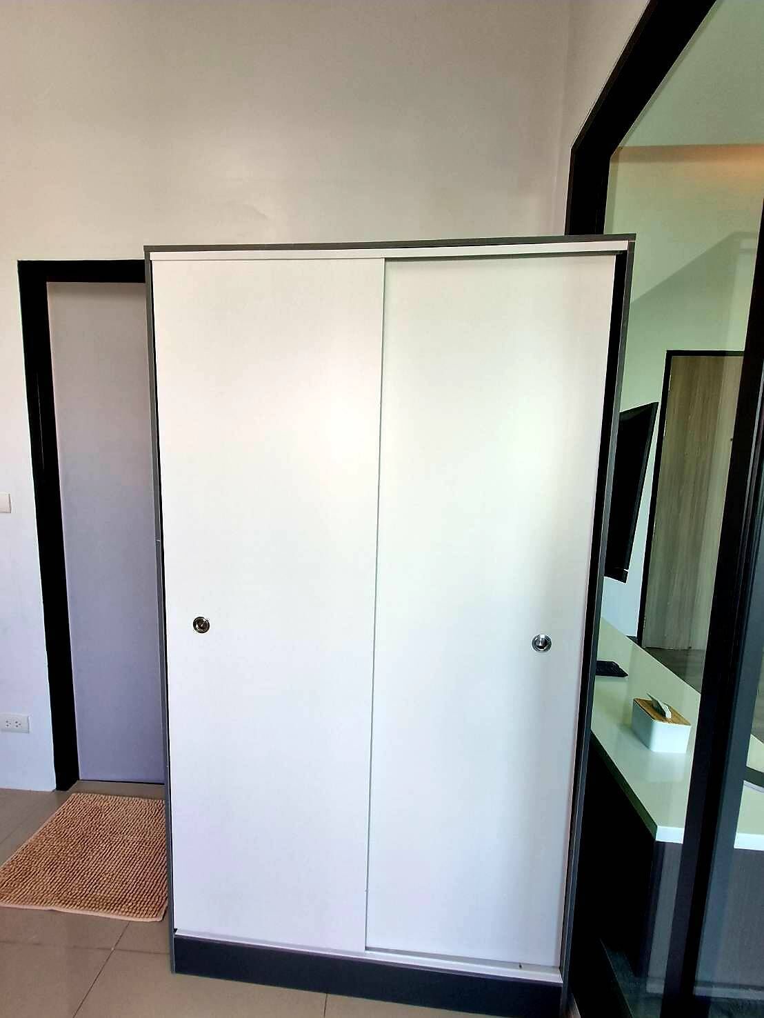 A white wardrobe with a mirrored closet door, a doormat, and a tiled floor.