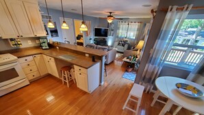 A modern kitchen with wooden flooring, white cabinetry, and pendant lighting. - No parties, quiet, 3 bed, 2 bath. (St. Louis)