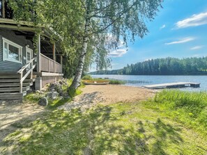 A cabin with a porch, a dock, and a lake view.