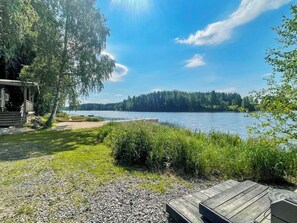 Une propriété au bord du lac, dotée d’une terrasse en bois, d’un quai et d’un chalet.