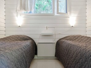 A bedroom with two beds, a window, and a radiator. - Vacation home Lepola by Interhome (Virrat)