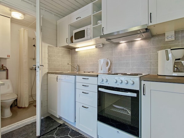 A compact kitchen with a microwave, oven, and coffee maker.