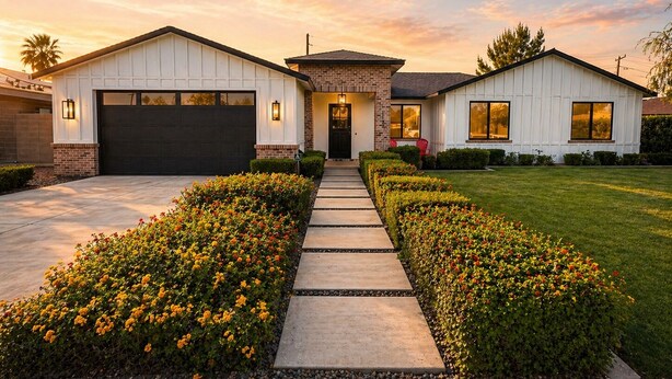 A two-story house with a garage, a front porch, and a well-maintained lawn.