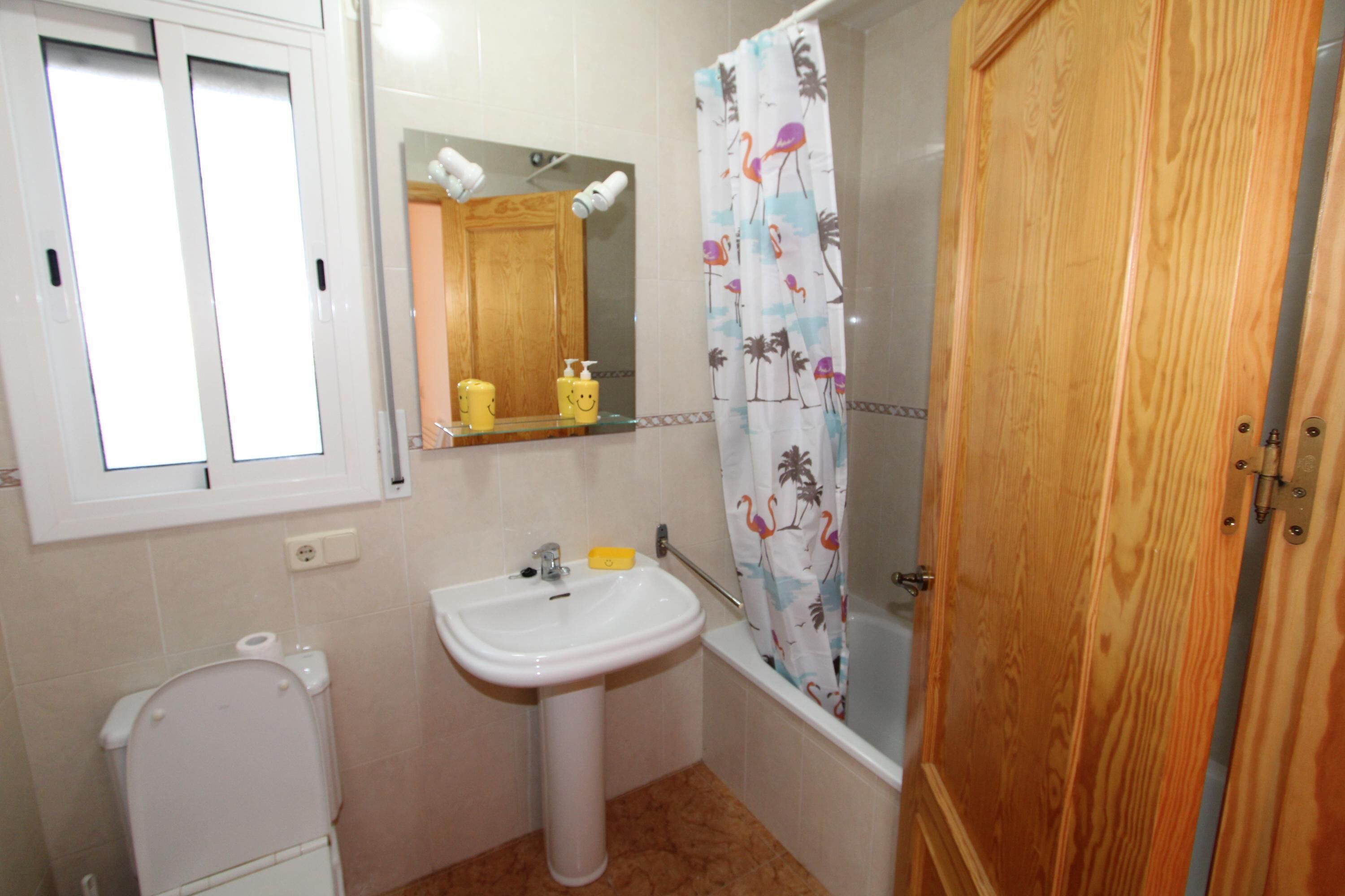 Een badkamer met toilet, wastafel en bad.