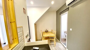 A small, modern room with a wooden dining table, a black countertop, and a ceiling fan. - Remarkable 2-Bed House in Ponta Delgada (Ponta Delgada)