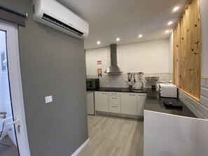 A modern kitchen with white cabinets, a stainless steel sink, a microwave, and a built-in oven.