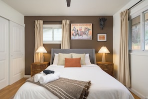 A neatly made bed with pillows, a blanket, and two bedside lamps.